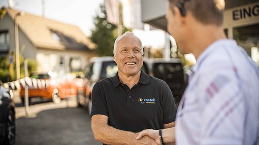 Verabschiedung durch einen Handschlag vor einem Auto