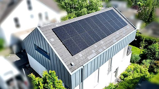 Einfamilienhaus aus der Vogelperspektive mit Photovoltaik-Modulen auf der Dachfläche