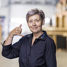 Daniela Schmidt, Ansprechpartnerin im Vertrieb, formt mit ihrer Hand ein Telefon