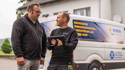 Beratungsgespräch vor einem enatek-Fahrzeug
