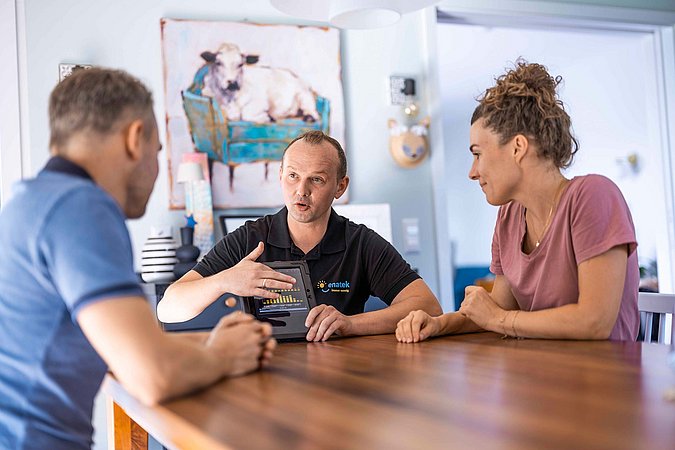 Eine Ehepaar und ein enatek Berater sitzen in einem Wohnzimmer bei einem Beratungsgespräch