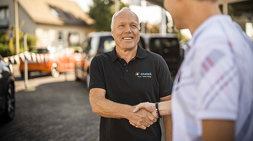 Reinhard verabschiedet einen Kunden Verabschiedung durch einen Handschlag vor einem Auto